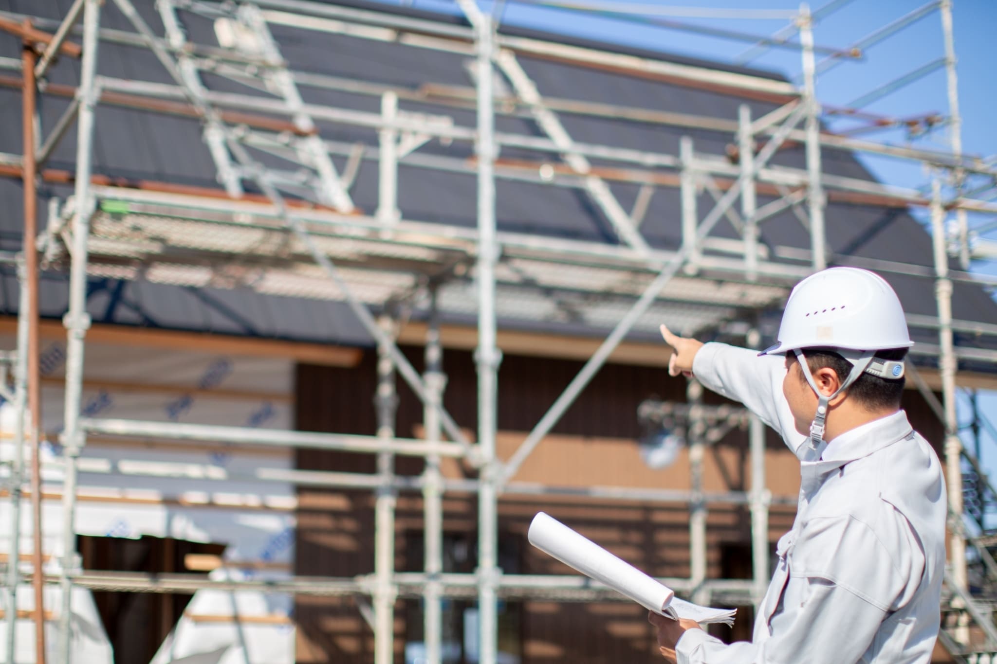 建設現場の前でOKhomeのスタッフが指差し確認をしながら施工を進めている