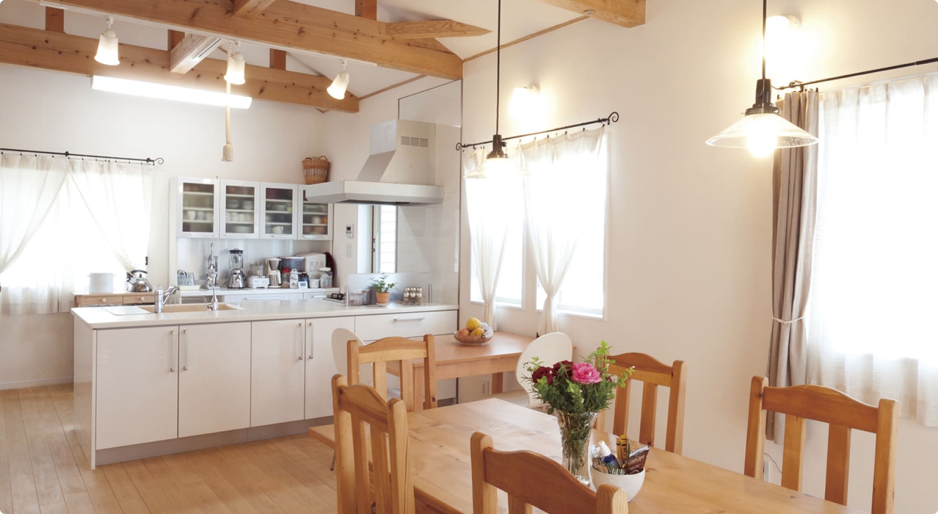 アイランドキッチンとダイニングテーブルの上にバラを飾っている