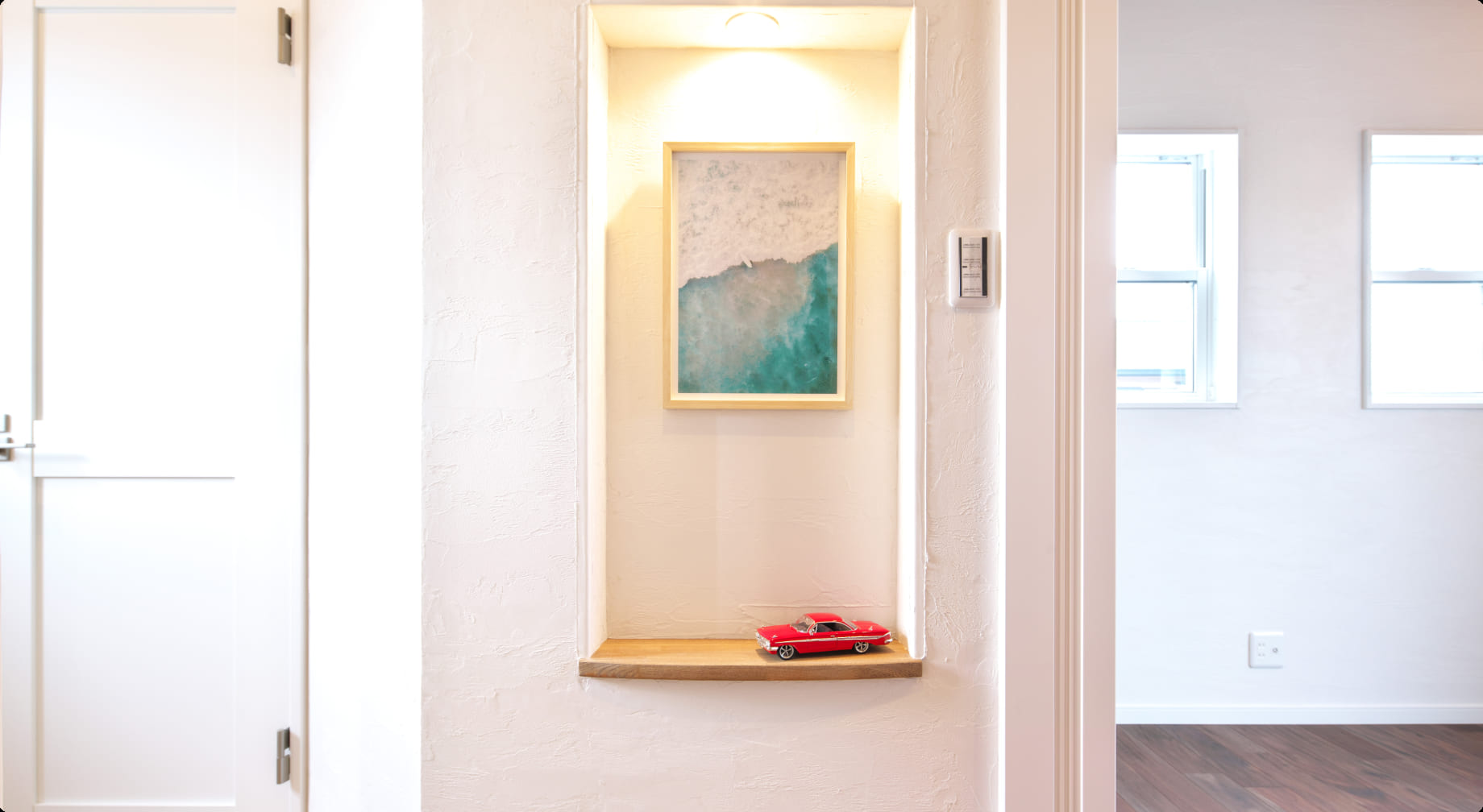 海を感じるアメリカ西海岸風の真っ白な壁と絵とスポーツカーのミニチュア